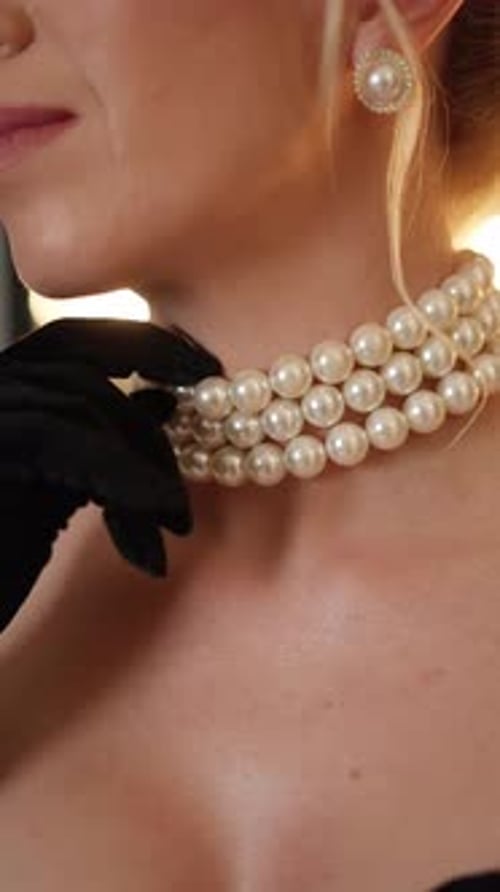 Elegant Woman with Pearl Necklace and Black Gloves