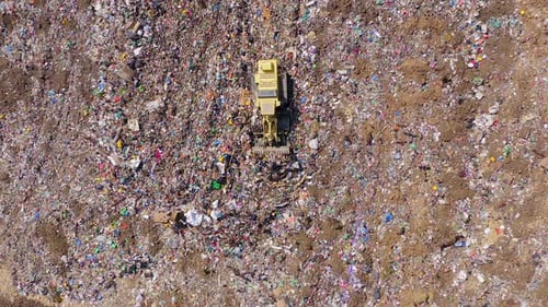Aerial View of Landfill with Bulldozer Flattening Garbage