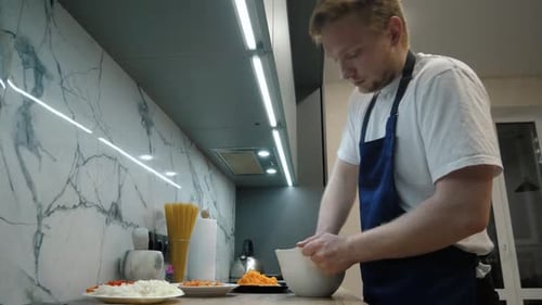 Man mixing ingredients in kitchen bowl