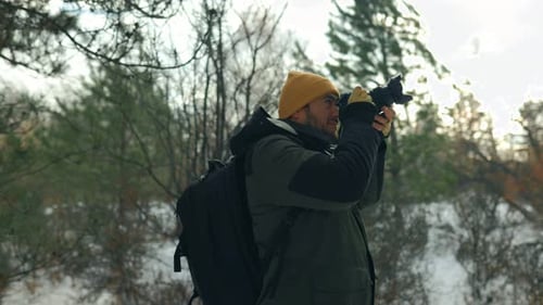 Man Taking Photos in Snowy Winter Forest