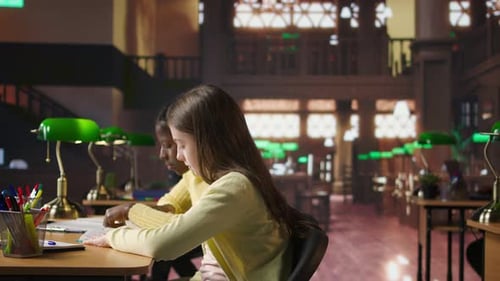 Preteen Girls Focus on Reading the Required Books at a Study Desk