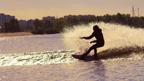 Man wakeboarding at sunset on a river