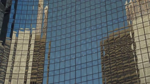 Buildings reflecting on skyscraper windows. Big city architecture with urban background. Reflective