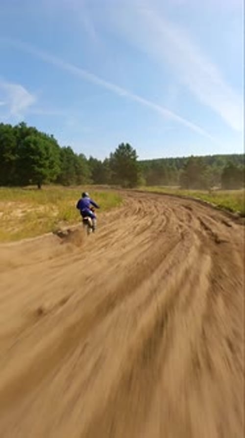 Dirt Bikes Racing Through Rural Dusty Terrain