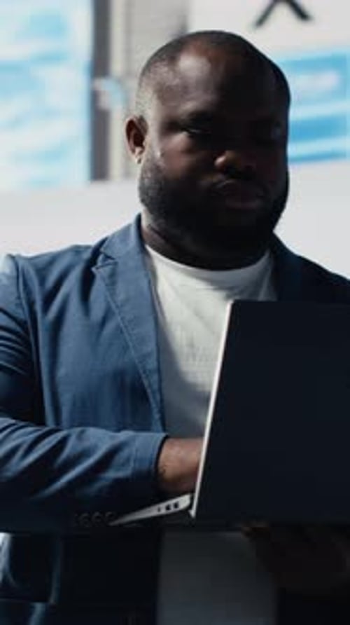 Vertical Video Black Coder Focused on Programming with Laptop in a High Tech Workspace