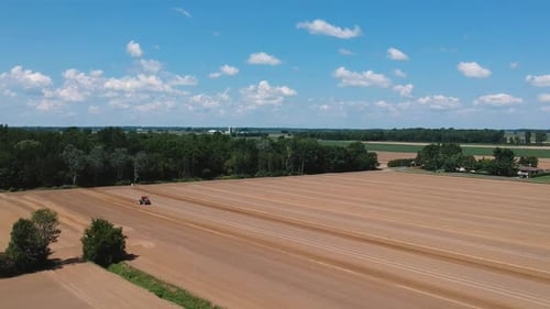 Tractor at work, prepares the field for planting seeds. Aerial view.