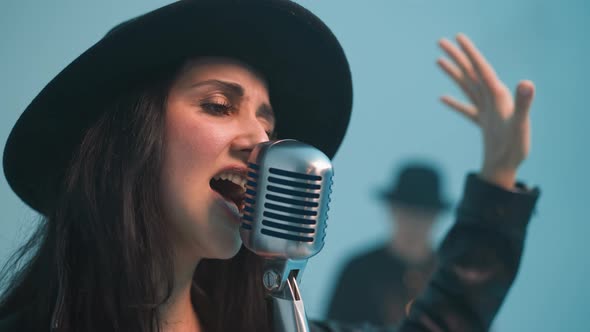 Passionate Singer in Black Hat and Leather Jacket Singing with Vintage ...