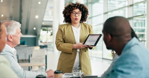 Woman Presents Tablet Data to a Diverse Team