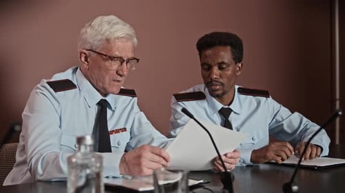 Two Men in Uniforms Reviewing Documents