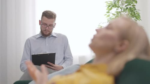 Woman Talking To Therapist On Couch In Office