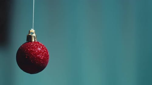 Red Glitter Ornament Swinging on Thread
