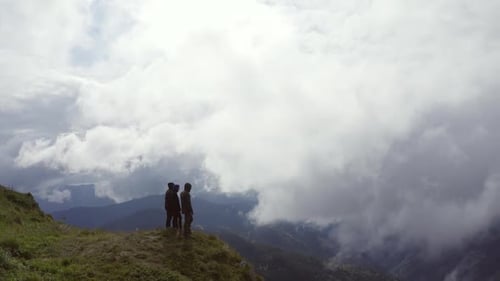 The four people standing on a mountain on a cloud background