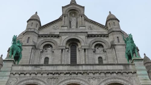 Fachada frontal da Basílica do Sagrado Coração com estátuas gêmeas em Paris