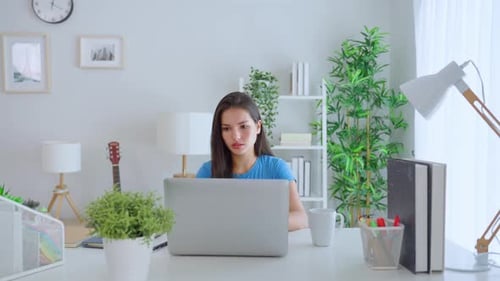 Young Woman Working on Laptop at Home Office