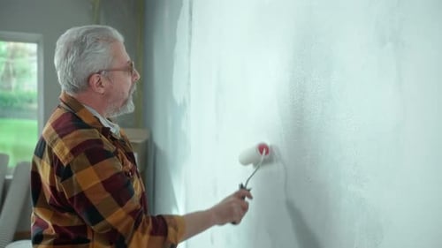 Man Painting Interior Wall with Paint Roller
