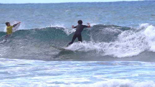 Surfer rides a wave in slow motion at Gran Canaria beach,