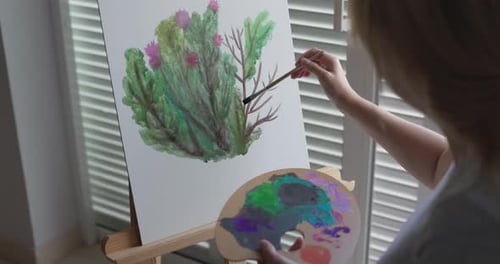 Female artist painting with watercolors on canvas at home - Creative art work and hobby concept