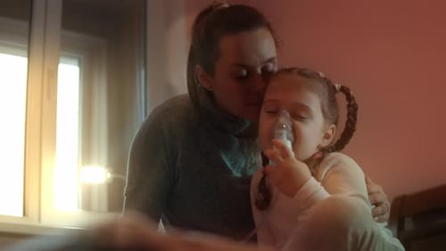 Caring Woman Helping Child with Breathing Treatment