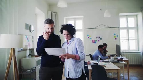Young business team collaborating on laptop in modern open office space