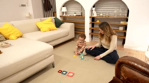 Woman and Infant Play with Toys on Rug