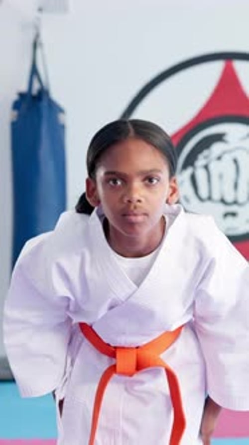 Child Practicing Karate Bow in Dojo