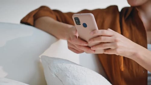 Smiling Woman Using Phone Relaxing at Home
