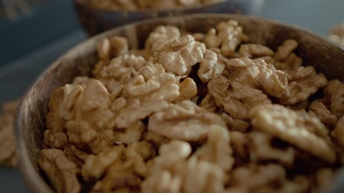 Walnut Kernels in Wooden Bowls Close Up