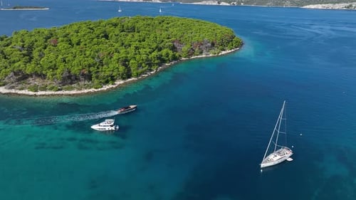 Pleasure Yachts near Beautiful Lush Island in Turquoise Sea AERIAL