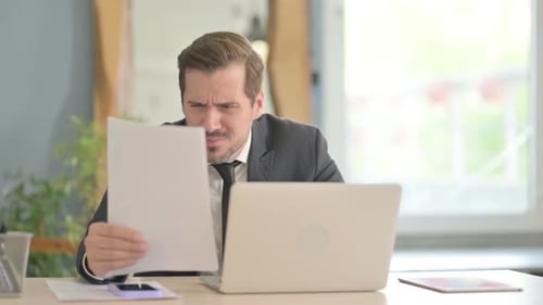 Man Frustrated with Paperwork in Office