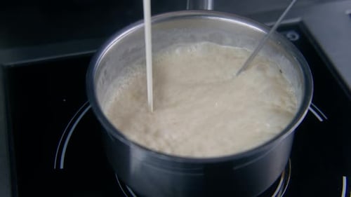 Cuire les mélanges de sauce au fouet et verser la crème dans le faitout
