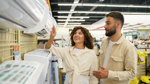 Newlyweds Couple Choosing Air Conditioning Unit in Electronics Store