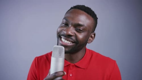 Man Singing a Song Young AfroAmerican Singer Stands Near Microphone with Happy Smile Sings and Makes