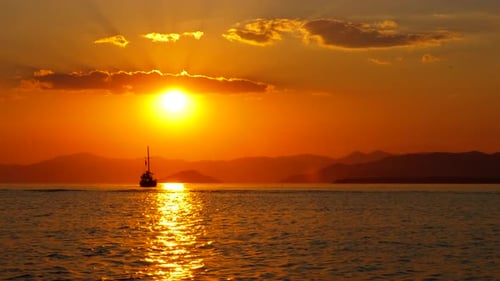 Golden Sunset Over Ocean with Sailboat