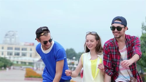 Joyful Friends Exchanging Smiles and Sharing News on a Sunny Street