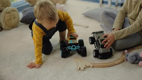 Toddler Plays with Toy Trucks on Carpet