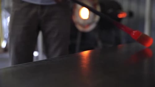 Glass Blower Shaping Molten Glass at Workshop