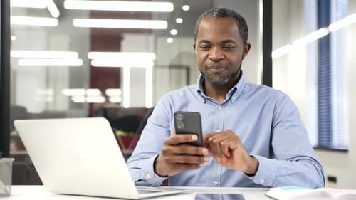 Man Using Mobile Phone at Workplace Desk