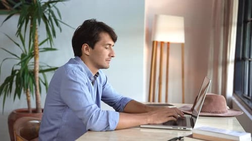 Business Man Working in Home Office and Typing on Keyboard of Laptop Computer