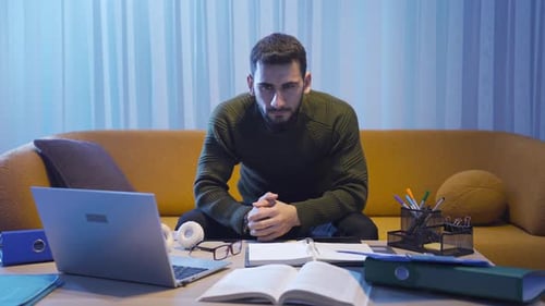 Young Adult Man Sitting on Couch Looking Sad