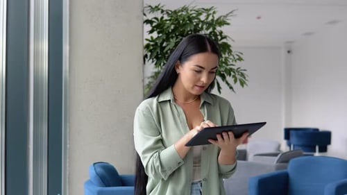 Businesswoman Works on Tablet in Modern Office
