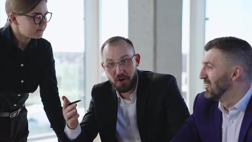 Two men and a woman in the office discussing work. Colleagues meeting and searching solutions