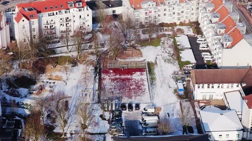 Top Down Shot of a House Block Soccer Field and Playground Covered in Snow in Urban Bielefeld