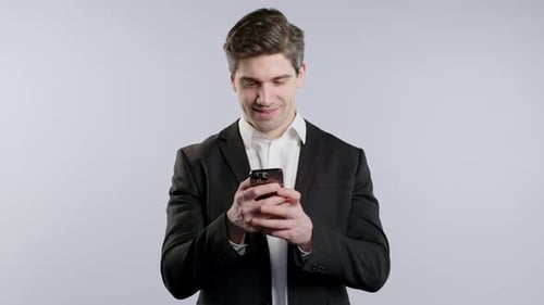 Young Adult Smiling While Using Mobile Phone