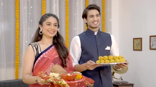 Smiling Couple Celebrating Diwali with Traditional Items