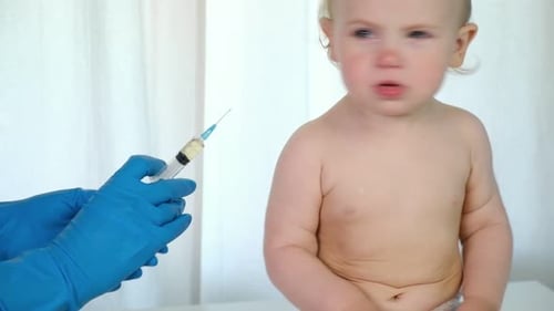 Doctor Vaccinating Crying Baby in Clinic