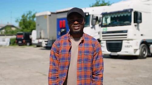 Portrait of African American Truck Driver on Parking Lot Looking at Camera