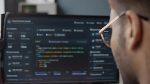 Développeur masculin programmant un logiciel sur un ordinateur de bureau au bureau