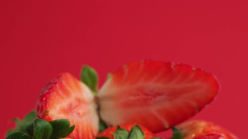 Reife Erdbeeren rotieren auf rotem Grund.