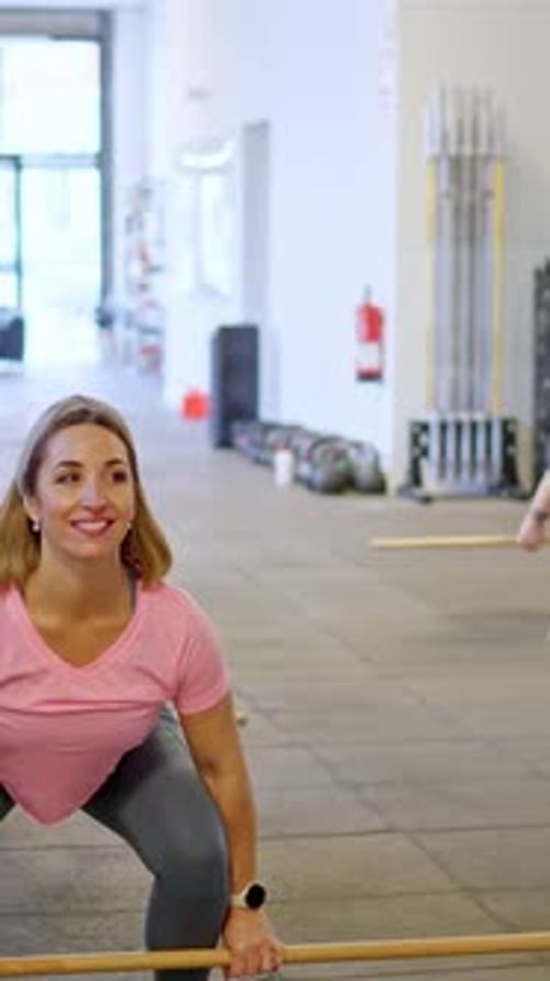 Women Do Squats with Barbell in Gym