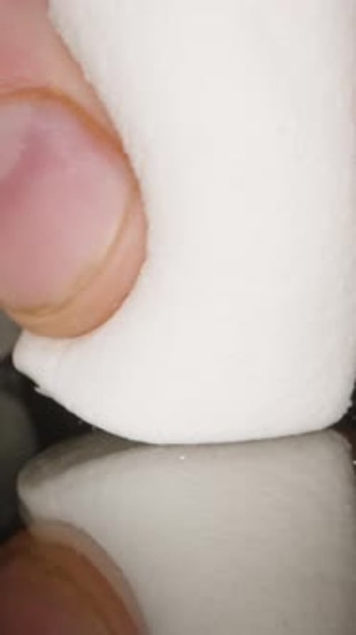 Vertical video. Soft Tender Marshmallows Squeezed by Male Hand, Unhealthy Sweet Food. Dolly Slider,